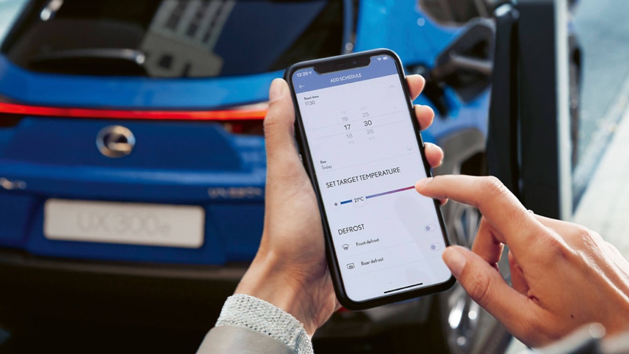 Smartphone vor einem Lexus UX 300e