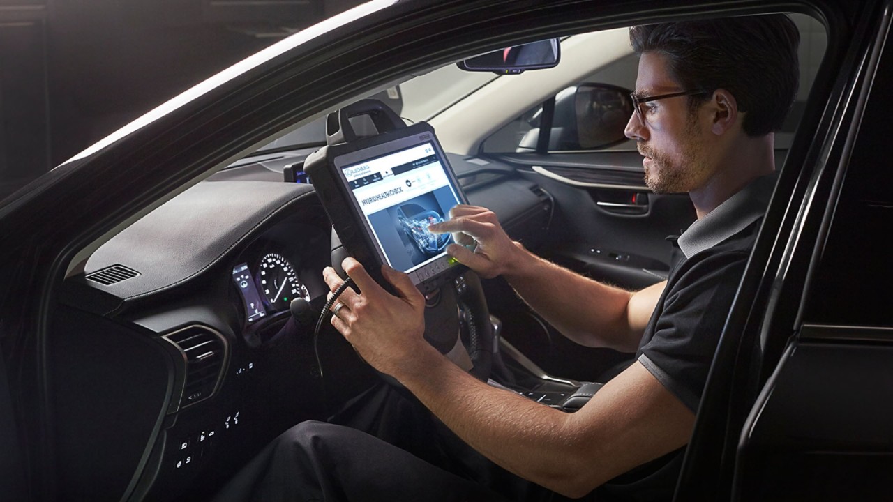 Ein Mann bedient ein Tablet in einem Lexus Fahrzeug