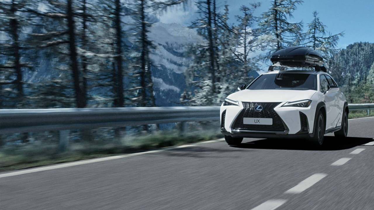 Ein Lexus UX fährt durch eine beschneite Landschaft