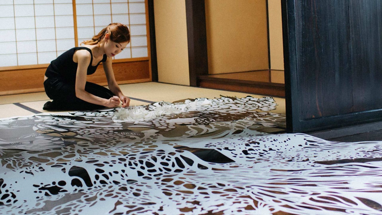 Eine japanische Künstlerin arbeitet an einem traditionellen Papierschnitt