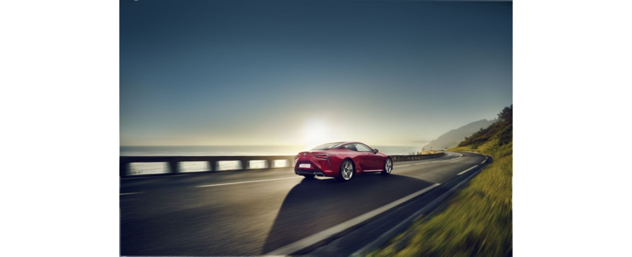 Lexus LC im Sonnenaufgang an einer Küstenstraße