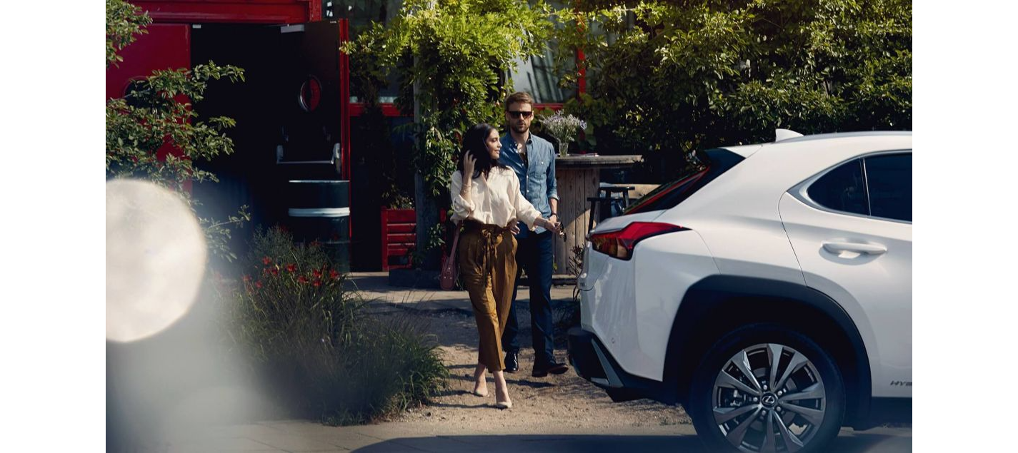Paar auf der Straße hinter weißem Lexus