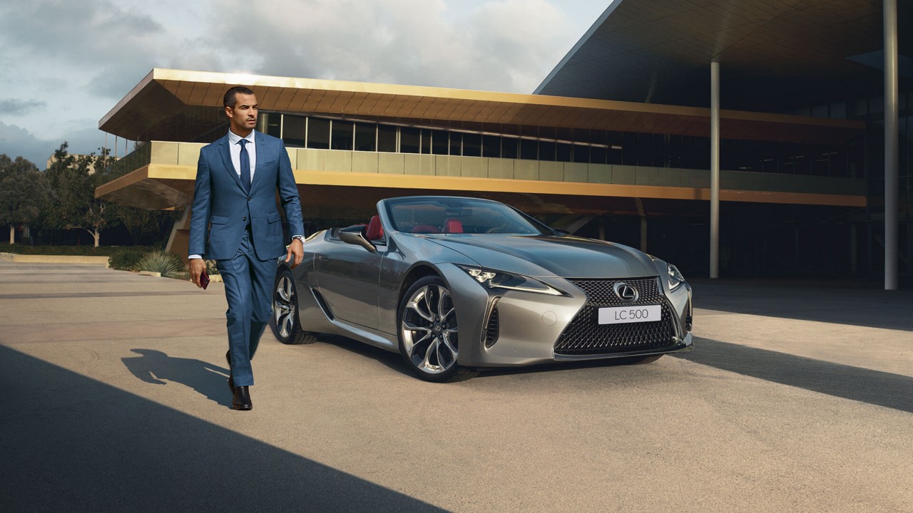 Junger Mann im Anzug neben Lexus LC Cabriolet
