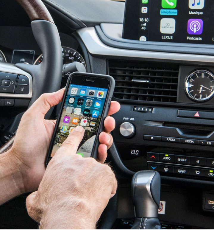 Ein Smartphone wird in einem Lexus Wagen bedient