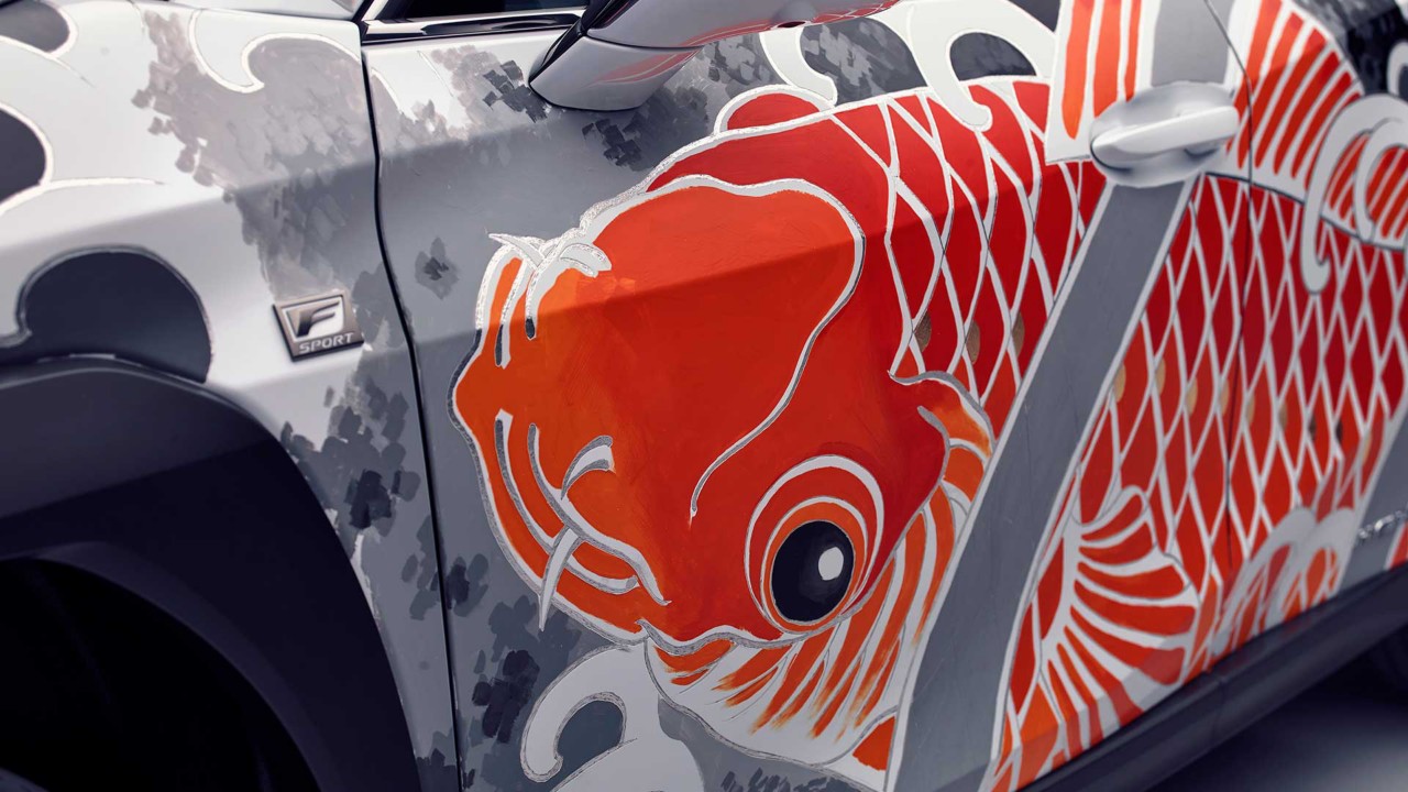 Detailansicht sich tättowierten Lexus UX mit farbenfrohem Fischmotiv