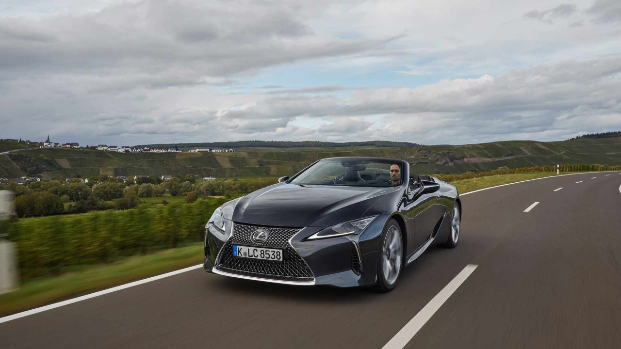 Der neue Lexus LC500 fährt gemütlich auf einer schnellen Straße in grüner Natur.