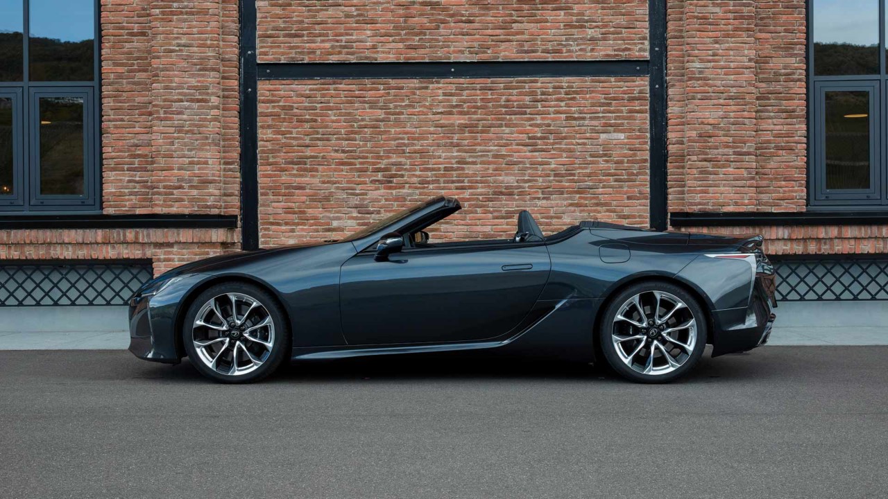 Seitenansicht des LC Cabriolet vor einem Backsteinhaus.