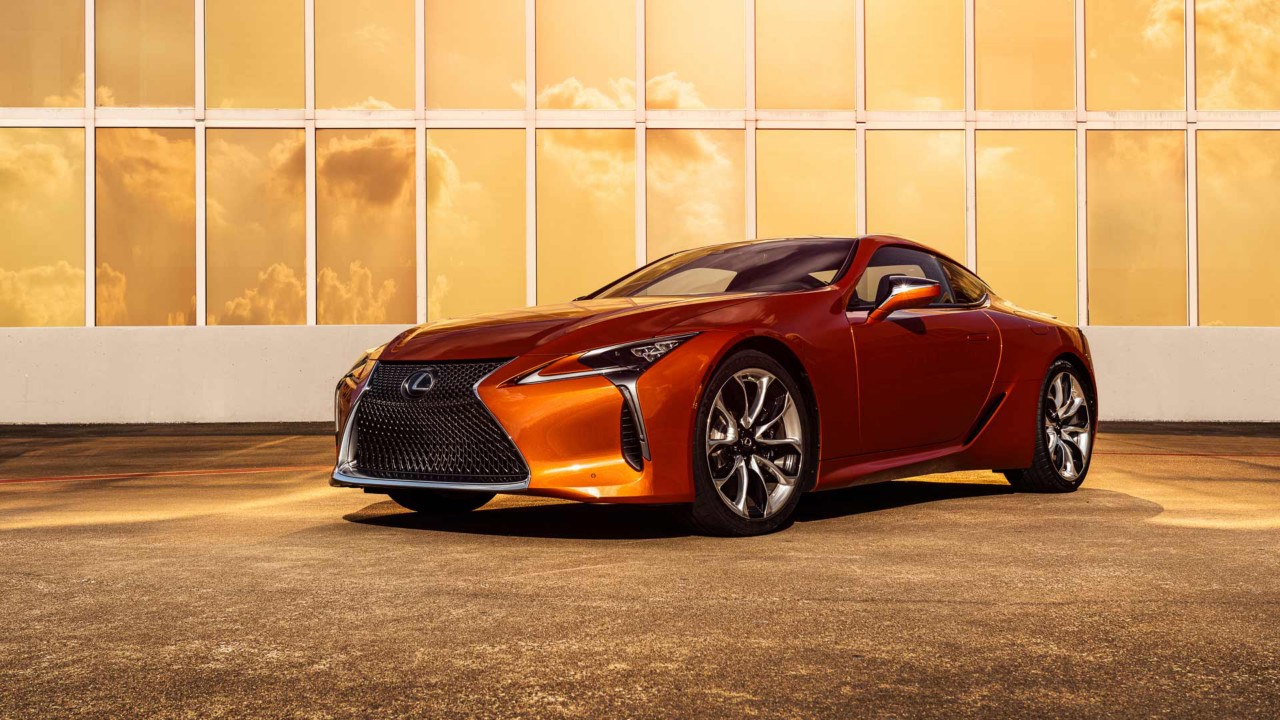 Lexus LC Coupé vor einem modernen Haus bei Sonnenuntergang.