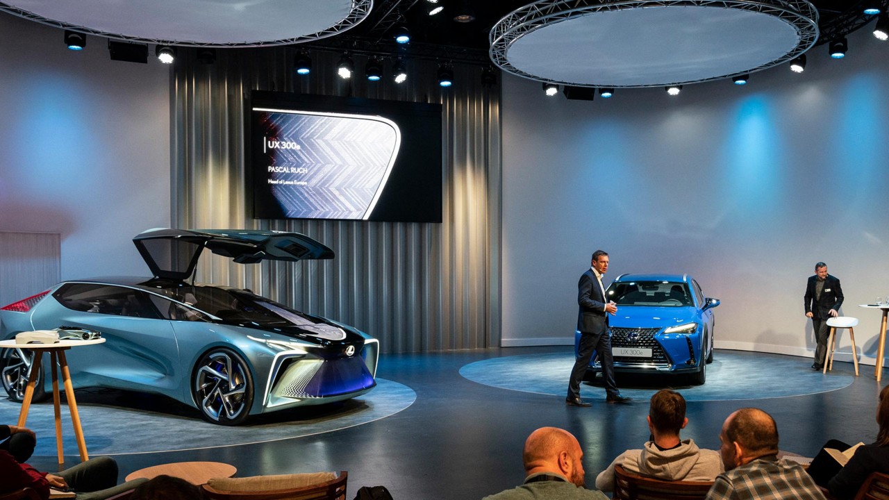 zwei Lexus Fahrzeuge im Showroom mit Moderator und Puplikum 