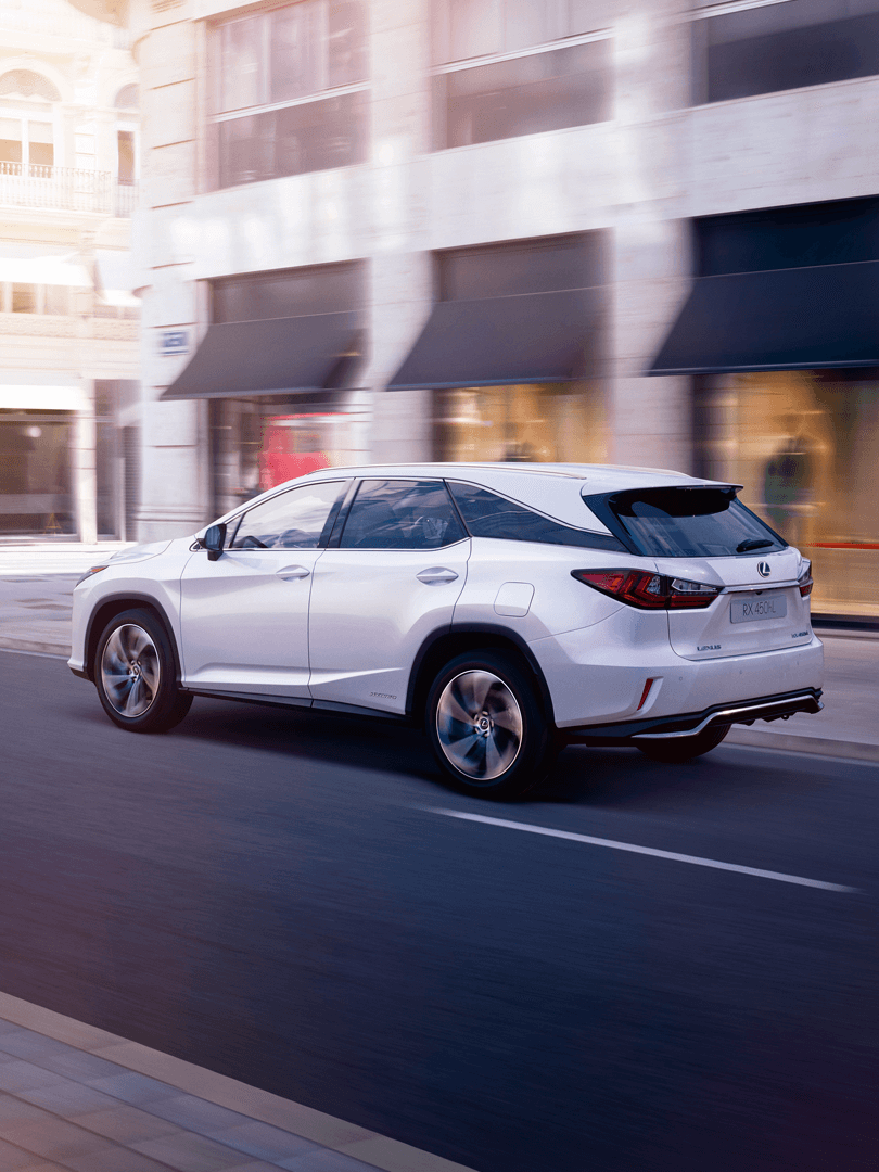 Ein silberner Lexus RX L fährt auf einer Straße in der Stadt