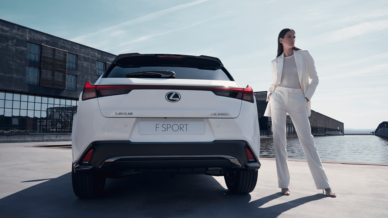 Eine Frau stehr neben einem Lexus UX