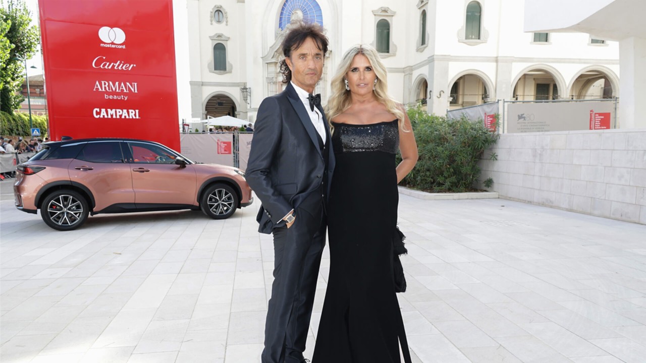 Tiziana Rocca and Giulio Base stood in front a Lexus at the Venice Film Festival